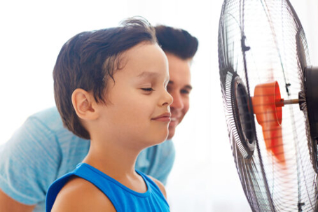 Kid and dad in front of fan