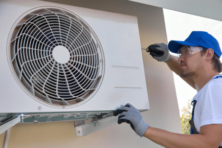 tech fixing a heat pump
